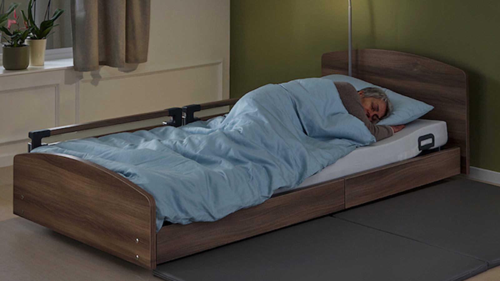 bedroom set up for palliative care at home with adjustable bed and overbed table