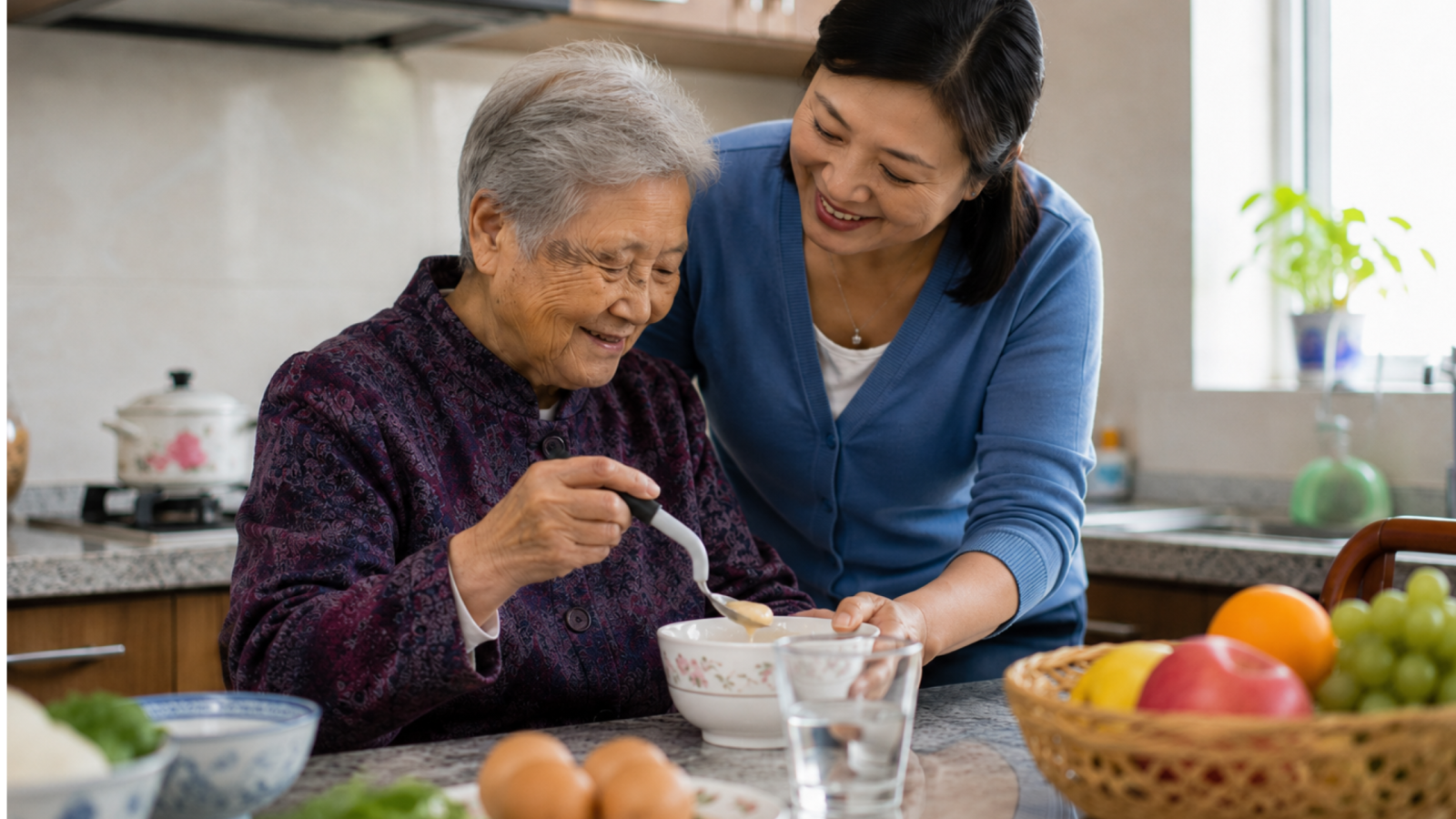 Chinese family carer helping an older woman use an assistive bendable spoon for daily care at home.
