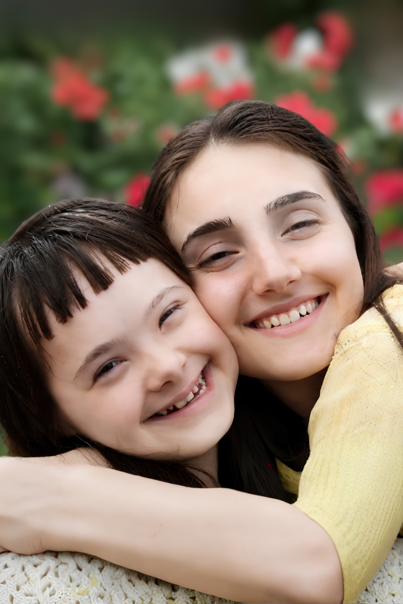 NDIS participant and carer smiling together outdoors