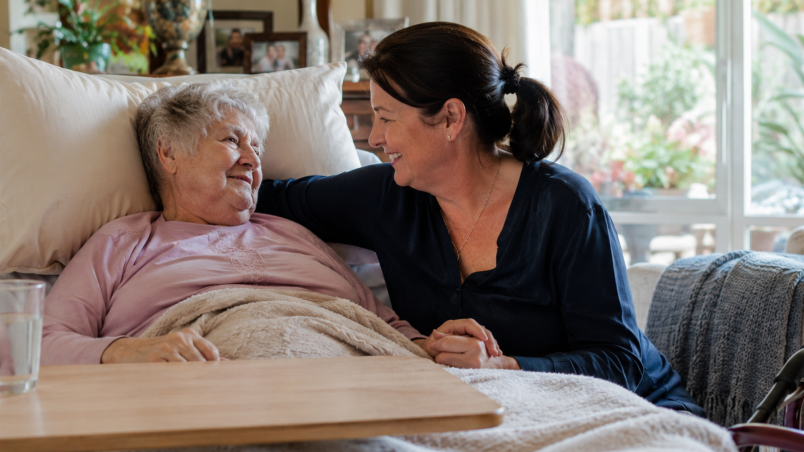 family carer supporting an older person at home with palliative care equipment